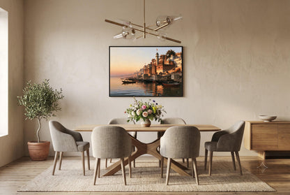 a modern dining room with a large wooden table surrounded by six upholstered chairs. Above the table, there is a framed picture of a cityscape with a river and boats. The room has a neutral color scheme with beige walls and a wooden floor, and there is a potted plant and a vase of flowers on the table.