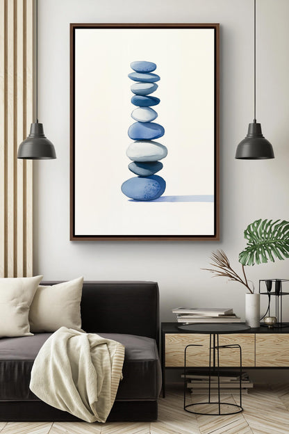 a modern living room with a black sofa, a framed artwork of stacked blue and white stones, and two black pendant lights hanging above the sofa.