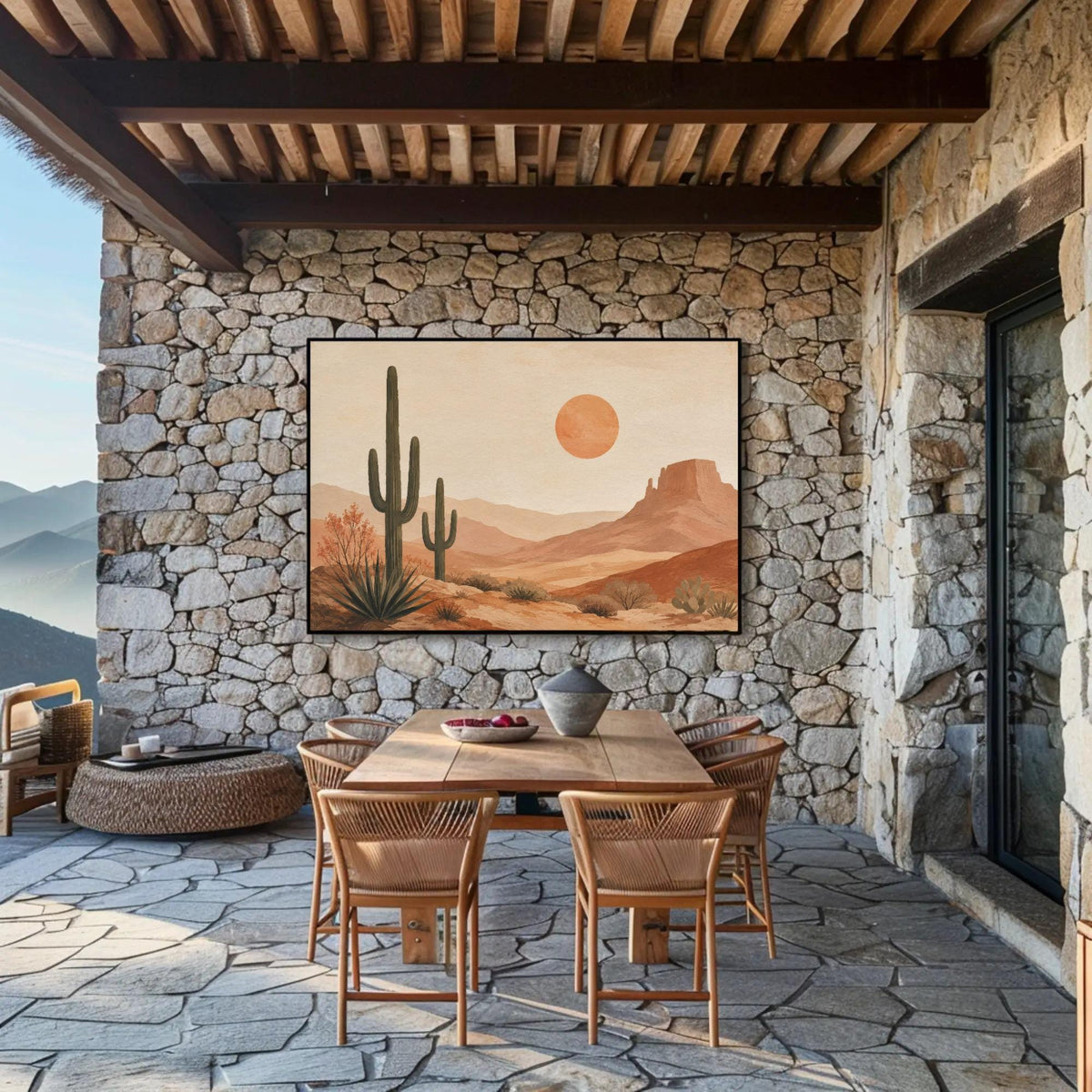 a desert-themed dining area with a stone wall, wooden table, and chairs. A large painting of a desert landscape with a cactus and a sun is displayed on the wall above the table.