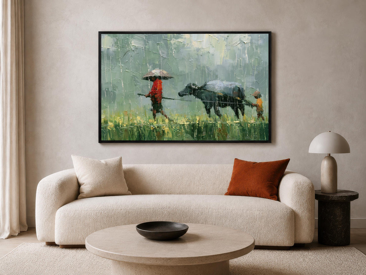 a living room with a large painting of a person walking a cow in a field hanging on the wall above a white sofa.