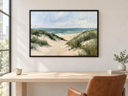 a serene beach scene with a sandy path leading to the ocean, framed and hung on a wall above a wooden desk with a leather chair.