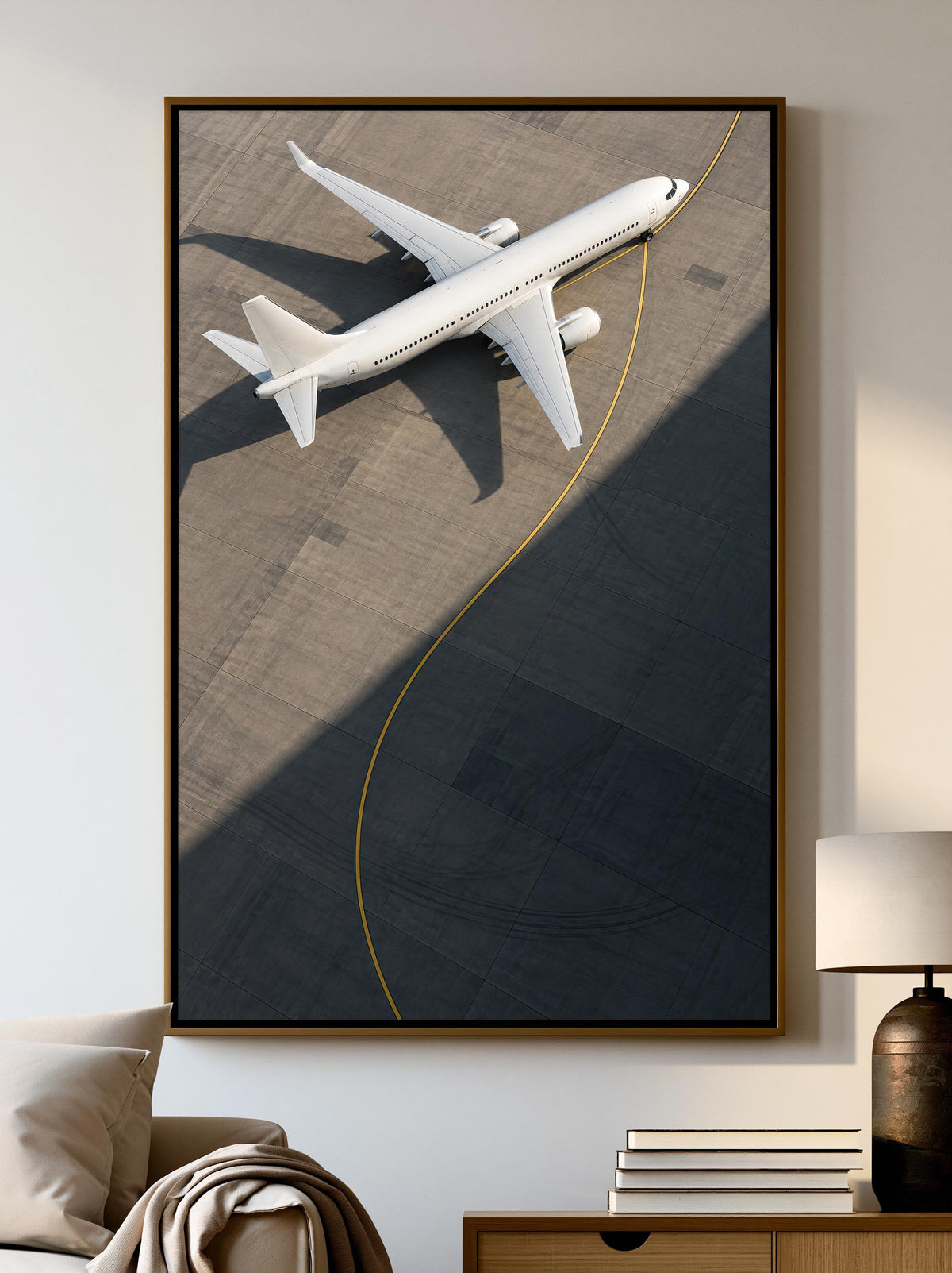 A large framed picture of a white airplane on an airport tarmac is displayed on the wall in a living room setting.