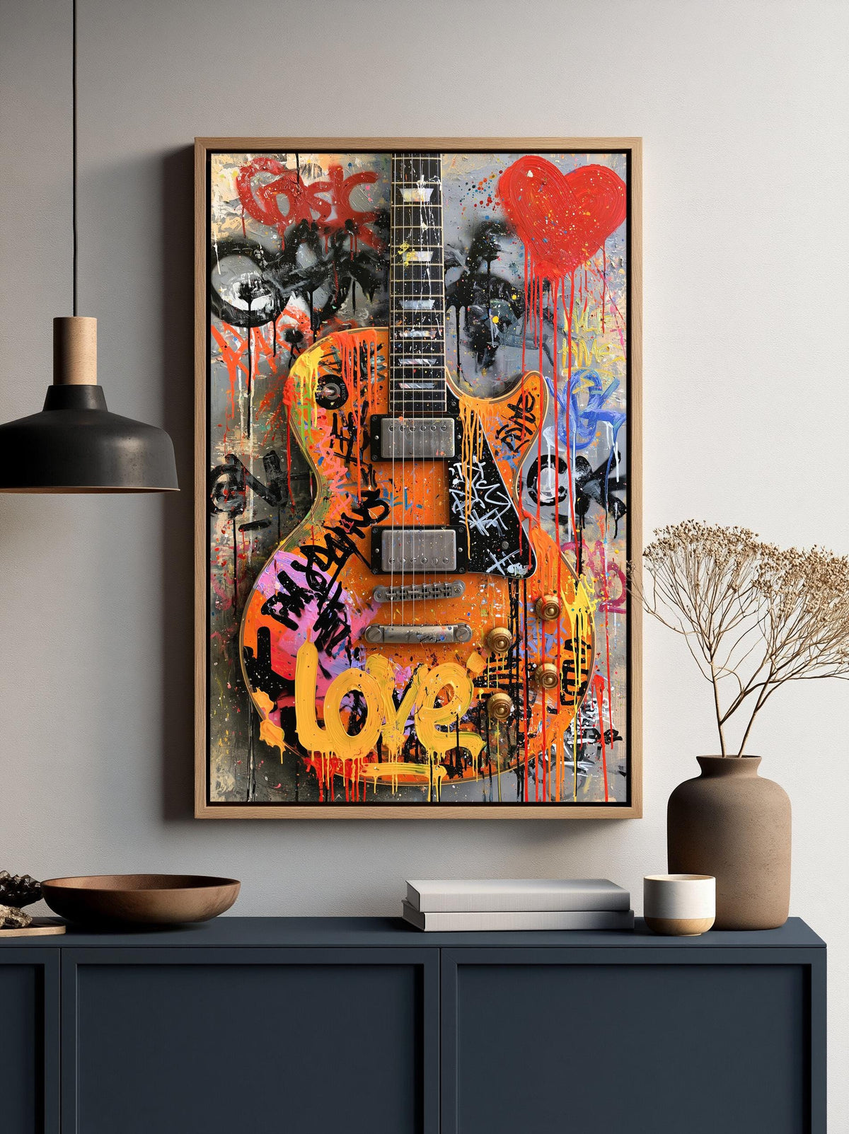a vibrant and colorful graffiti-style artwork of a guitar, with the word "LOVE" prominently displayed on it. The artwork is framed and hung on a wall, creating a striking visual focal point in the room.