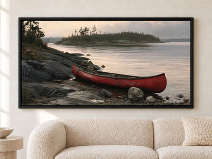 A large framed painting depicting a red canoe resting on a rocky shore, with a calm lake and trees in the background.