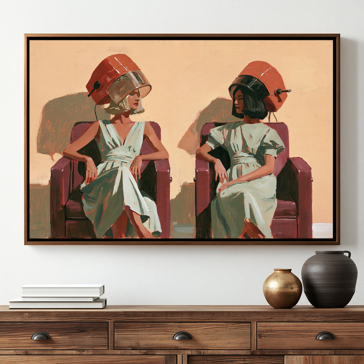 The image is a framed painting depicting two women sitting in chairs, each wearing a hair dryer on their heads.
