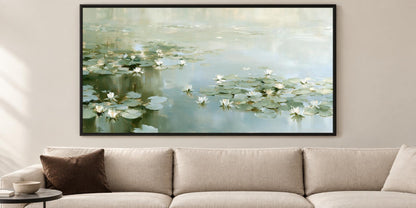 A large framed painting depicting a serene pond with lily pads hangs on the wall above a beige sofa in a living room.