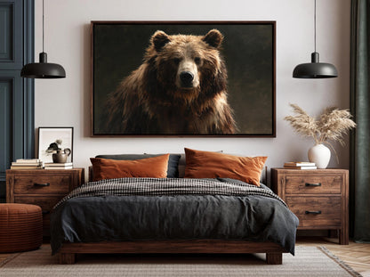 a large, dark brown bear in a portrait-style photograph, which is prominently displayed on the wall above a bed with a black and gray bedspread.