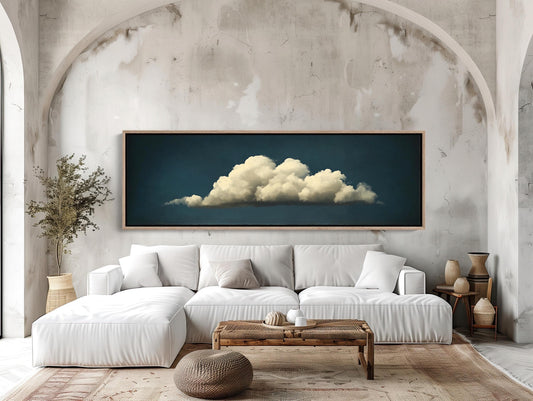 a living room with a white couch and a painting on the wall