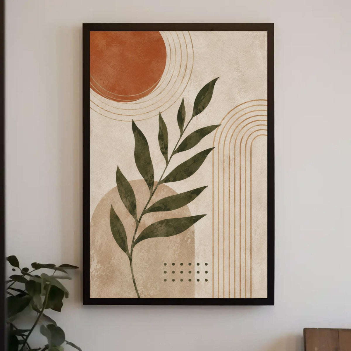 a framed abstract art piece with a leafy green plant design and geometric shapes in shades of orange and beige.