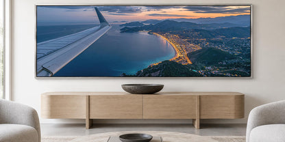 A large, high-resolution image of an airplane wing is displayed on the wall above a wooden entertainment center in a living room.