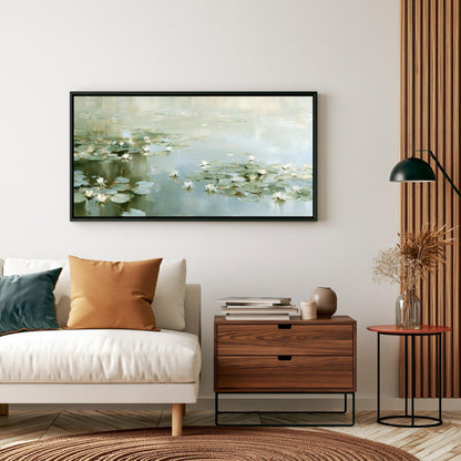 a living room with a white sofa, a wooden side table, and a framed painting of water lilies hanging on the wall above the sofa.