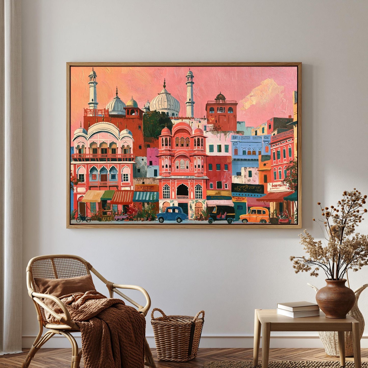 a large, colorful painting of a cityscape with buildings, cars, and people, hanging on a wall in a room with a chair, a table, and a vase of flowers.